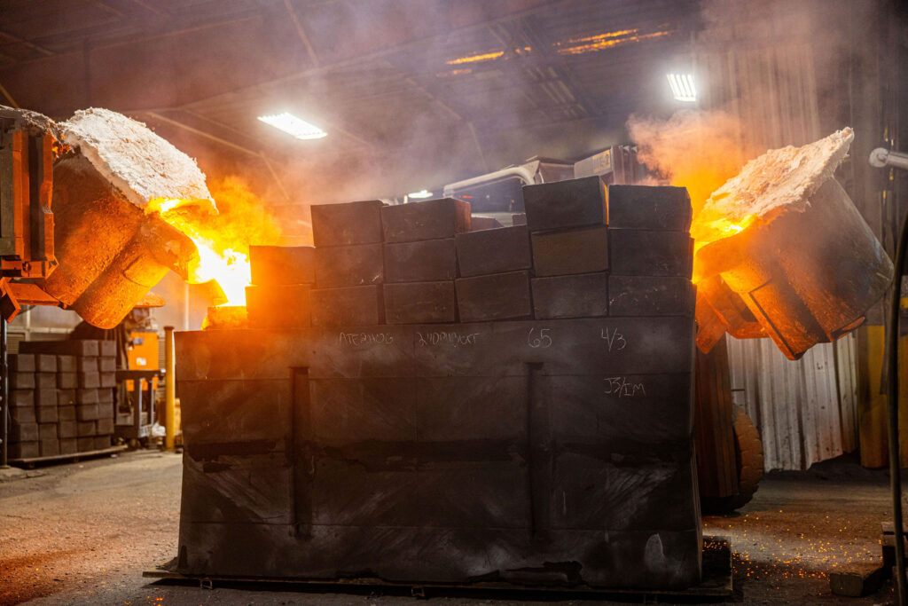 Two different metals being poured into a mold.