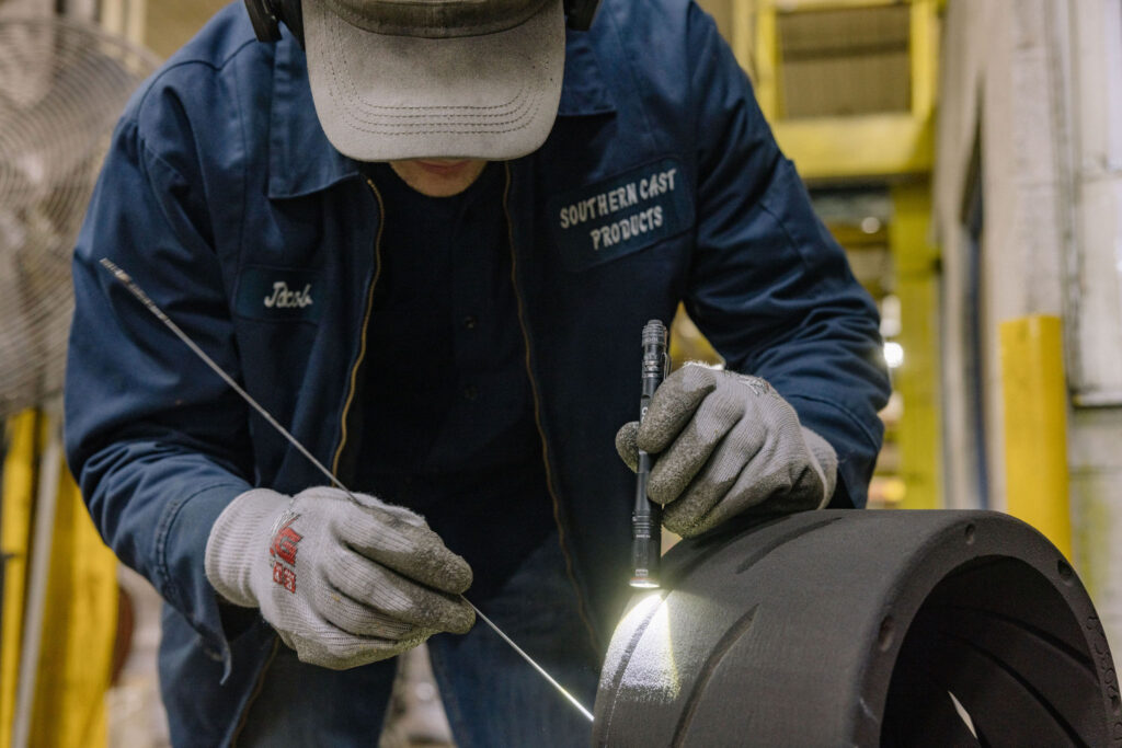 A man working on a 3D sand cast.