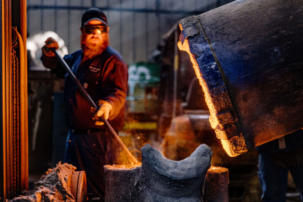 A man working during the metal pouring process.
